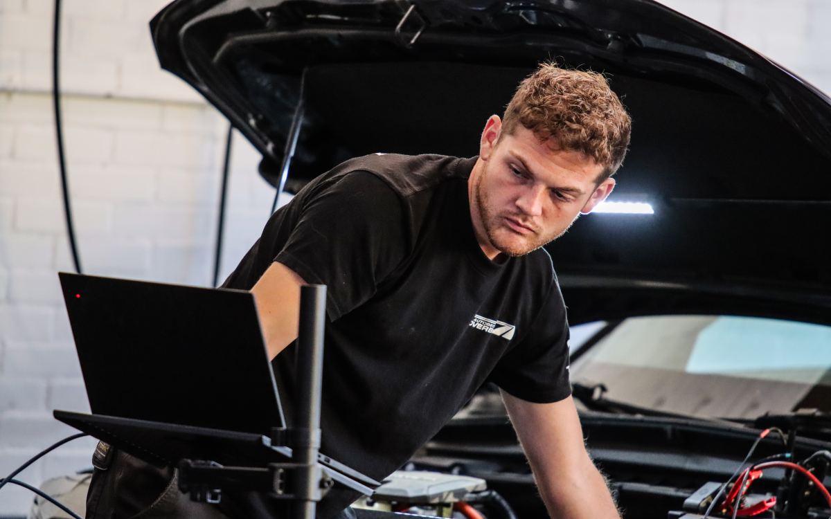 Stan Overbeek controleert de motorruimte van een auto