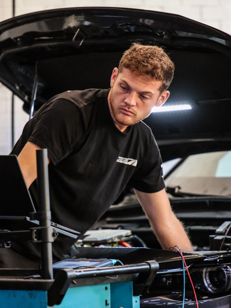 Stan Overbeek aan het werk onder de motorkap in de werkplaats van Autobedrijf Overbeek